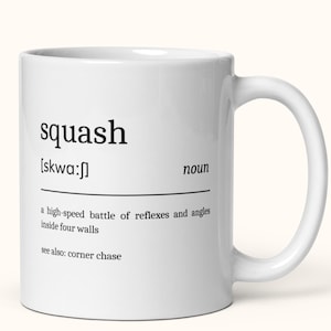 Könnte beinhalten: Weiße Keramiktasse mit dem Wort "squash" in schwarzer Schrift, phonetischer Aussprache und dem Wort "Nomen". Die Definition von Squash ist darunter abgedruckt. Ein Griff ist auf der rechten Seite.