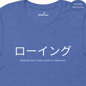 May include: Heather true royal blue t-shirt with white Japanese characters and the English text "Rowing, but it looks cooler in Japanese." The shirt also features the "StrideSuccess" logo.