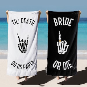 May include: Two white beach towels with black text and skeleton hand graphics. One towel says "Til' Death Do Us Party" with a skeleton hand making a rock and roll sign. The other towel says "Bride Or Die" with a skeleton hand making a middle finger gesture with a ring on the finger.