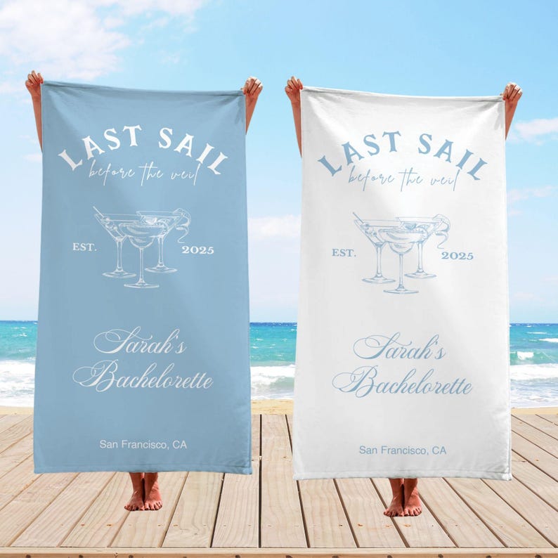 May include: Two beach towels with the text "Last Sail Before the Veil" and a drawing of three martini glasses. The towels are blue and white and have the text "Sarah's Bachelorette" and "San Francisco, CA".