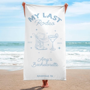 Pu&ograve; includere: Asciugamano da spiaggia bianco con testo blu che recita "My Last Rodeo Est 2025 Amy's Bachelorette Nashville, TN". L'asciugamano presenta anche un'illustrazione blu di un cappello da cowboy, stivali e un bicchiere di margarita.
