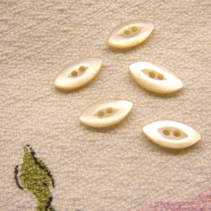 May include: A white ceramic mug with a black handle and the text "But First, Coffee" in a black, handwritten-style font. The mug is on a white surface.