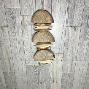 Peut inclure: Un mobile suspendu en bois composé de cinq pièces circulaires. La pièce supérieure est brune et les quatre autres sont blanches.