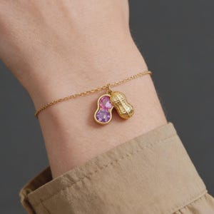 May include: A set of three ceramic mugs with a speckled, cream-colored glaze. Each mug features a different hand-painted floral design in shades of blue, green, and yellow. The mugs have a simple, rounded shape and a comfortable handle.