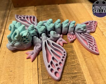 May include: A 3D printed, articulated, fantasy creature with wings. The creature is painted in shades of blue, pink, and purple. The wings are translucent and have a delicate, intricate design.