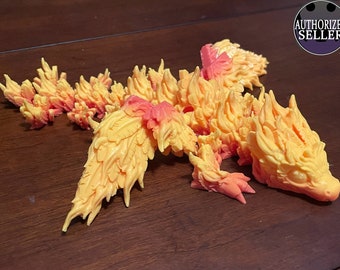 May include: A detailed, multi-piece, hand-painted, orange and yellow dragon figurine. The dragon is posed with its wings spread out and its head turned to the side. The figurine is made of a smooth, plastic-like material.