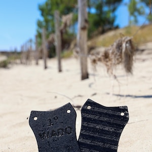 Peut inclure: Deux ailerons de planche de surf noirs imprimés en 3D. L'aileron de gauche porte l'inscription "1° WADO".