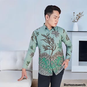 May include: A long-sleeved shirt with a green and brown floral pattern. The shirt has a button-up collar and a relaxed fit.