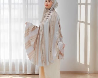 May include: A beige and white prayer garment with vertical stripes and a matching head covering. The garment is worn by a person standing in front of a window. The text "Rattanmerch" is visible in the bottom right corner.