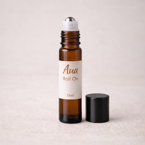 Könnte beinhalten: Braune Glas-Roll-on-Flasche mit silbernem Rollball-Aufsatz und schwarzer Kappe. Auf dem Etikett steht "Aua Roll On" und "15ml". Die Flasche ist für ätherische Öle oder Parfums bestimmt.