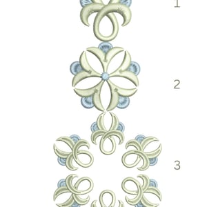 May include: An embroidered design in cream and light blue, featuring floral and abstract shapes. The design includes a large flower, several smaller floral elements, and a repeating abstract motif. The embroidery is detailed and appears to be machine-made.
