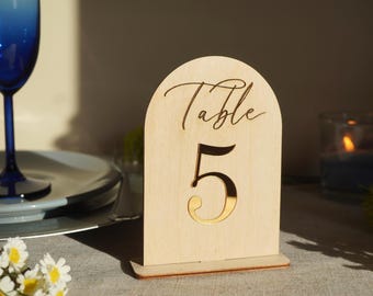 May include: Wooden table number sign with a gold number 5 and the text "Table" in a cursive font.