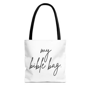 Könnte beinhalten: Weiße Tragetasche mit schwarzen Henkeln. Die Tasche zeigt den handgeschriebenen Text "my bible bag". Das Design ist schlicht, mit dem Text mittig auf der Vorderseite. Die Henkel sind schwarz und die Tasche ist aus strapazierfähigem Material.