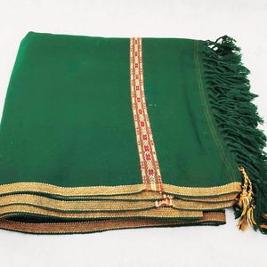 May include: A green shawl with gold and red trim and fringe. The shawl is made of a soft, warm material and is perfect for keeping you warm in the winter.