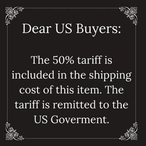 May include: A black rectangular sign with a white decorative border featuring ornate corner flourishes. The text reads: Dear US Buyers: The 50% tariff is included in the shipping cost of this item. The tariff is remitted to the US Goverment.