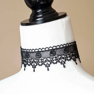May include: A black lace choker necklace with a delicate floral design.