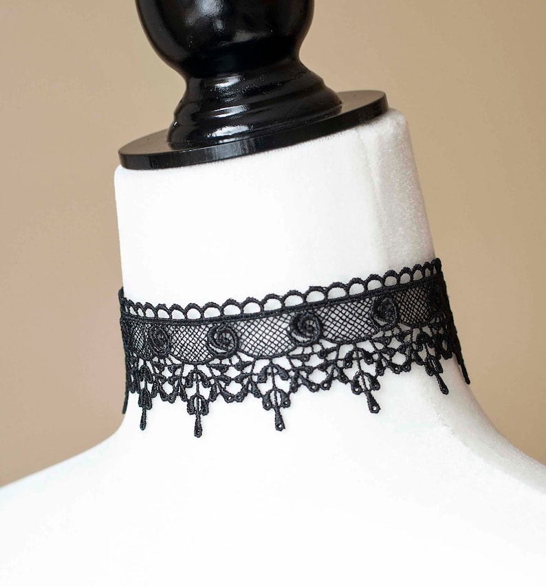 May include: A black lace choker necklace with a delicate floral design.