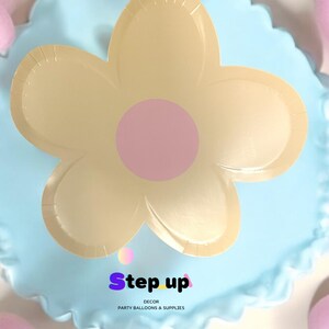 May include: A light blue balloon with a yellow flower design and a pink centre. The balloon has a ruffled edge and the text "Step up Decor Party Balloons & Supplies" printed on the bottom.