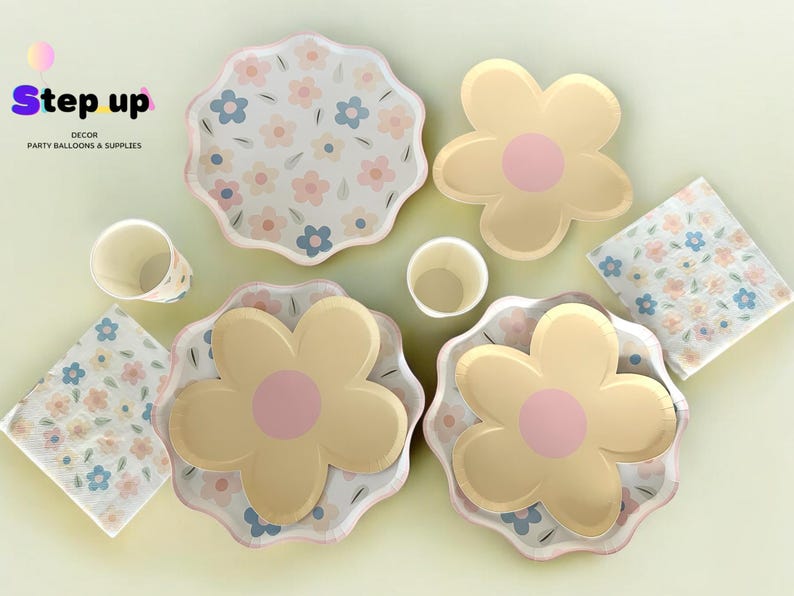 May include: A set of floral-themed party supplies, including plates, napkins, and cups. The plates feature a white background with pastel pink, blue, and yellow flowers. The napkins have a similar floral pattern, and the cups are white with a light blue rim.