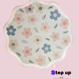 May include: White paper party plates with a pink, blue and peach floral pattern. The plates have a scalloped edge and are ideal for a spring or summer party.
