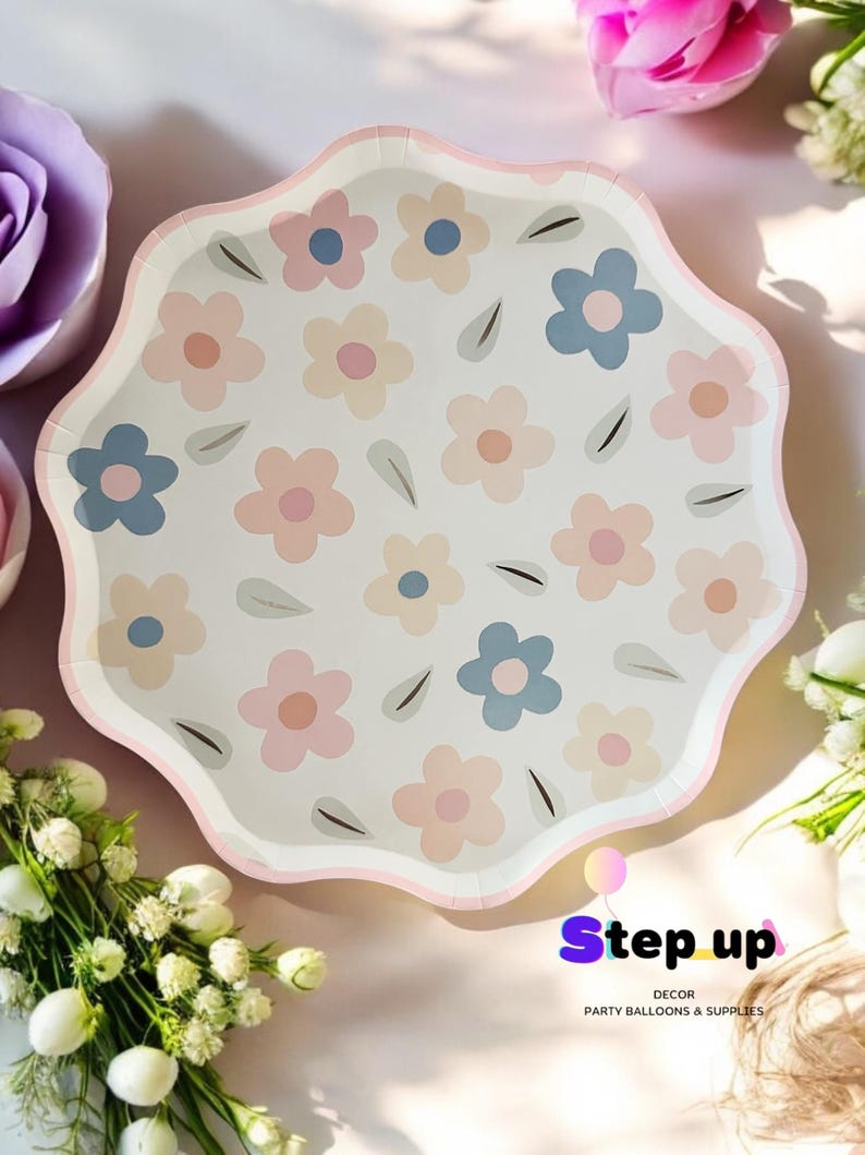 May include: White paper party plates with a pink, blue and beige floral pattern. The plates have a scalloped edge and are ideal for a spring or summer party.