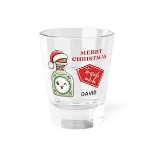 May include: A clear shot glass with a festive design. It features a cartoon tequila bottle wearing a Santa hat, a red tag with the words "Te-quila mucho," and the name "DAVID." The words "MERRY CHRISTMAS" are also printed on the glass.