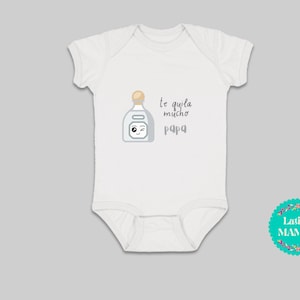 May include: White baby bodysuit featuring a cartoon tequila bottle and the text "Te quila mucho papa". The bodysuit has short sleeves and a snap closure. A Latina Mamas logo is in the bottom right corner.