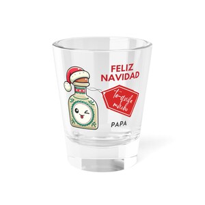 May include: A clear shot glass with the words "FELIZ NAVIDAD" and "Te-quila mucho PAPA" printed on it. The glass features a cartoon tequila bottle wearing a Santa hat.