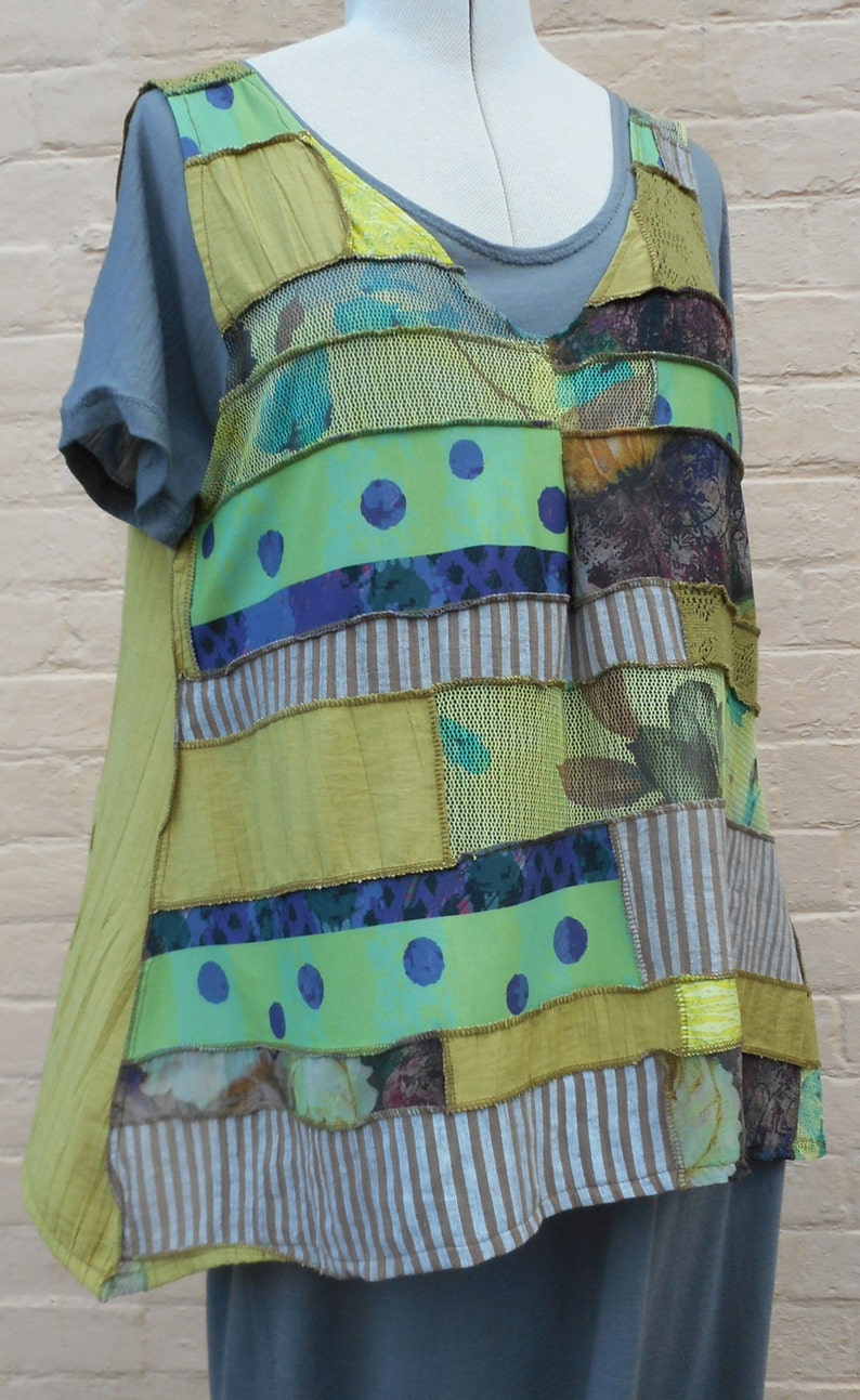 以下が含まれることがあります： 緑、茶色、青のパッチワークトップにメッシュのオーバーレイが施されています。トップは異なる生地で作られており、ゆったりとした流れるようなフィット感です。