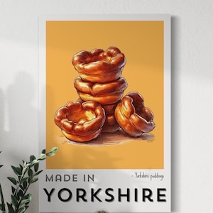 May include: A poster with a yellow background featuring a stack of Yorkshire puddings. The text "MADE IN YORKSHIRE" is at the bottom of the poster. The text "Yorkshire puddings" is written in smaller font above the text "MADE IN YORKSHIRE".