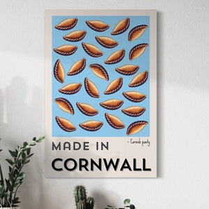 May include: A blue and white poster with the text "MADE IN CORNWALL" and a pattern of brown Cornish pasties. The text " - Cornish pasty" is below the main text.