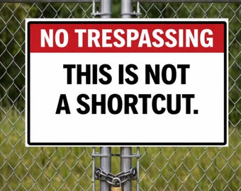 May include: A rectangular sign with the words "NO TRESPASSING" in red and "THIS IS NOT A SHORTCUT" in black. The sign is attached to a chain-link fence with a padlock.