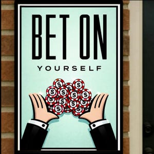 May include: Framed poster with the text "BET ON YOURSELF". The image shows cartoon hands holding casino chips. The chips are red, white, and black. The background is a light teal colour. The poster is framed in black.