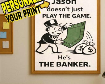Könnte beinhalten: Gerahmter Druck mit einem Monopoly-Themen-Design. Das Kunstwerk zeigt eine Cartoon-Bankier-Figur, die ein grünes Spielbrett und Geldsäcke hält. Der Text lautet: "Jason spielt nicht nur das Spiel. Er ist der Banker."