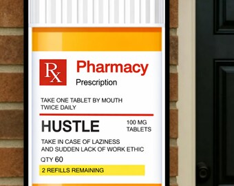 May include: A framed sign resembling a prescription bottle, with a white label and orange top. The label reads "Pharmacy Prescription" and includes instructions to take "Hustle" tablets twice daily. The sign also states "2 Refills Remaining".