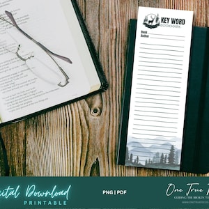 Può includere: Segnalibro stampabile con una scena di montagna e il testo "Key Word Bookmark" in alto. Il segnalibro ha righe per scrivere note e il testo "Book Author" in alto. Il segnalibro è su una superficie di legno con un libro e degli occhiali.
