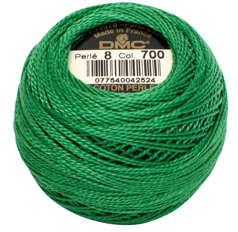 May include: A ball of bright green DMC Perl&eacute; cotton thread, color 700, with a label indicating it's made in France. The thread is tightly wound, showcasing its texture and color. Ideal for embroidery and needlework projects.