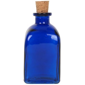 May include: A cobalt blue glass bottle with a cork stopper. The bottle is square shaped and has a smooth, polished finish.