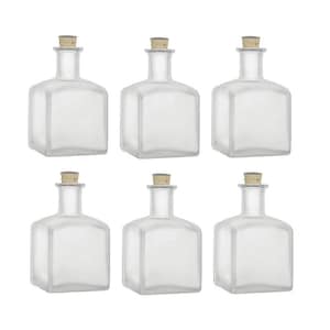 Puede incluir: Juego de seis botellas de vidrio transparente con tapones de corcho. Las botellas son de forma cuadrada y tienen un acabado esmerilado.