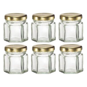 Puede incluir: Seis tarros de vidrio transparente con tapas doradas. Los tarros tienen forma hexagonal y están vacíos. Las tapas son redondas y brillantes. Estos tarros son adecuados para guardar objetos pequeños o para proyectos de manualidades.