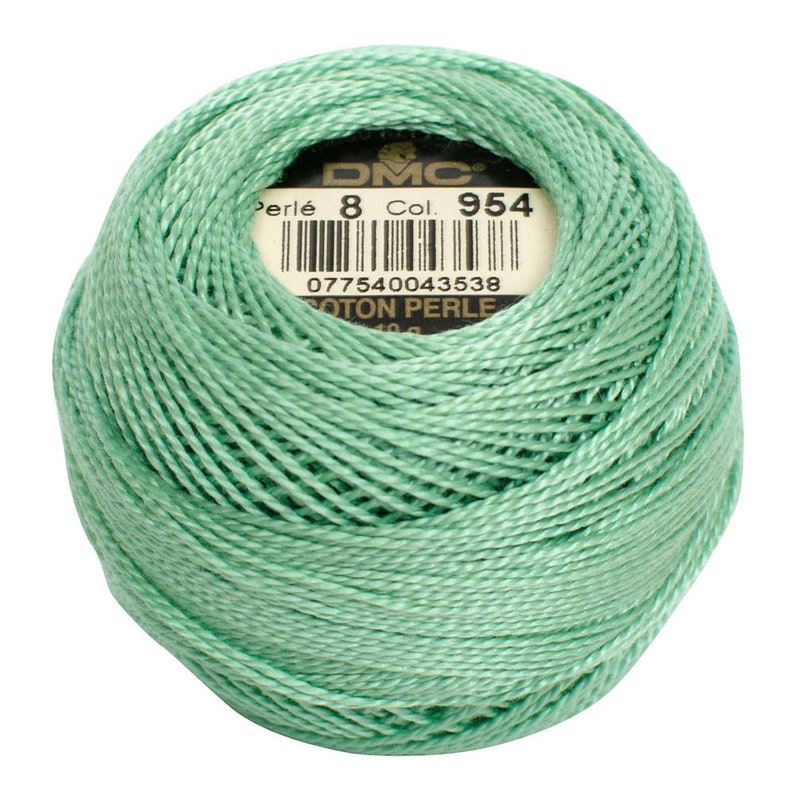 May include: A ball of DMC Perl&eacute; cotton thread in a soft, mint green color. The label indicates it is size 8, color 954, and COTON PERLE. The thread is tightly wound, showing the texture of the individual strands.