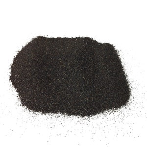 May include: A pile of black sand, a fine-grained material often used in landscaping and aquariums.