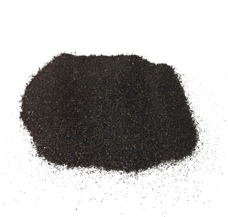 May include: A pile of black sand, a fine-grained material often used in landscaping and aquariums.