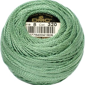 May include: A ball of DMC Perle cotton thread in a soft green color, labeled with "8 Col. 320" and a barcode. The thread is tightly wound, showing the texture of the fibers. Made in France.