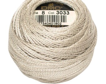 Puede incluir: Una madeja de hilo de algodón perlado DMC, color 3033, en un tono beige claro. La etiqueta indica el tamaño 8. El hilo está bien enrollado, mostrando la textura de los hilos individuales. Ideal para bordados y otras manualidades.