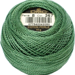 May include: A ball of green DMC Perl&eacute; cotton thread, Col. 367, 10 g. The label includes a barcode and the text "COTON PERLE". The thread is tightly wound, showing the texture of the yarn. Ideal for embroidery and other needlecraft projects.