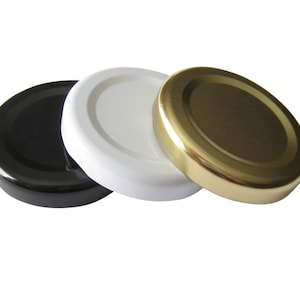 May include: Three round jar lids, one black, one white, and one gold.