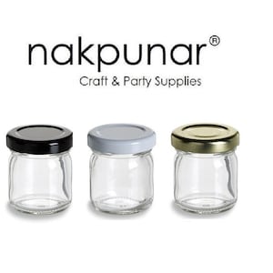 Puede incluir: Tres tarros de vidrio con tapas. Los tarros son de vidrio transparente y las tapas son negras, blancas y doradas.