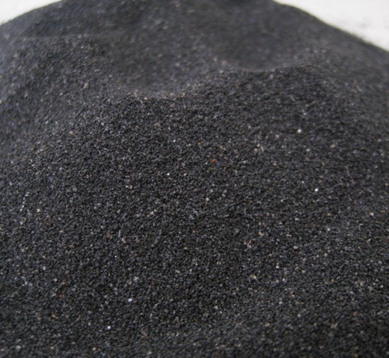 May include: A close-up of black sand, showing the individual grains of sand.