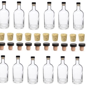 K&ouml;nnte beinhalten: Klare Glasflaschen mit schwarzen Korken und Naturkorken. Die Flaschen haben eine abgerundete Form und sind leer. Die Korken gibt es in zwei Ausf&uuml;hrungen: Naturkork und Korken mit schwarzem Kopf.